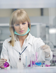 Image showing female researcher holding up a test tube in lab