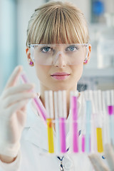 Image showing female researcher holding up a test tube in lab