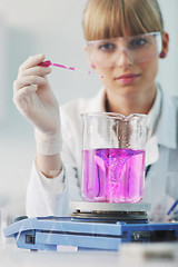 Image showing female researcher holding up a test tube in lab