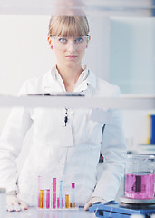 Image showing female researcher holding up a test tube in lab