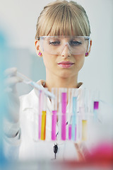 Image showing female researcher holding up a test tube in lab