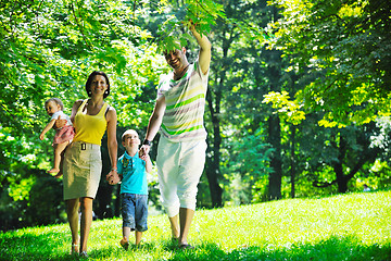 Image showing happy young couple with their children have fun at park