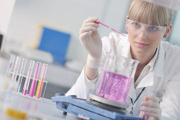 Image showing female researcher holding up a test tube in lab