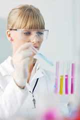 Image showing female researcher holding up a test tube in lab