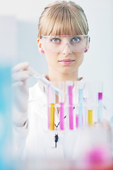 Image showing female researcher holding up a test tube in lab