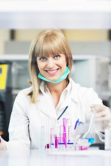 Image showing female researcher holding up a test tube in lab