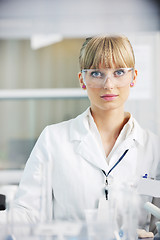 Image showing female researcher holding up a test tube in lab