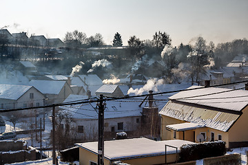 Image showing non ecologic smoking chimneys in small village