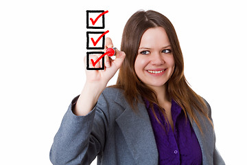 Image showing Young woman writing a check mark