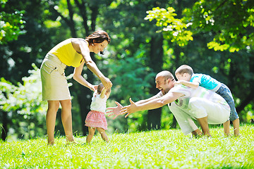 Image showing happy young couple with their children have fun at park