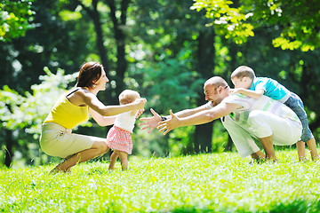 Image showing happy young couple with their children have fun at park