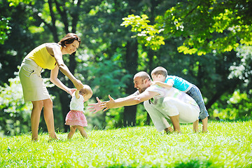 Image showing happy young couple with their children have fun at park