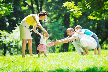 Image showing happy young couple with their children have fun at park