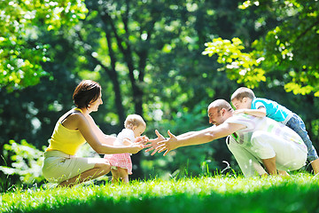 Image showing happy young couple with their children have fun at park