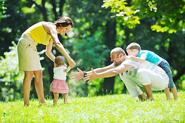 Image showing happy young couple with their children have fun at park