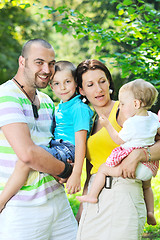 Image showing happy young couple with their children have fun at park