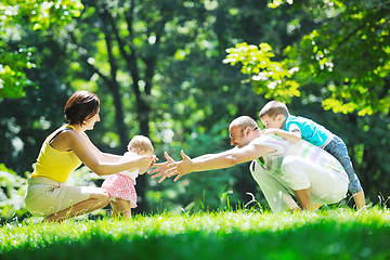 Image showing happy young couple with their children have fun at park