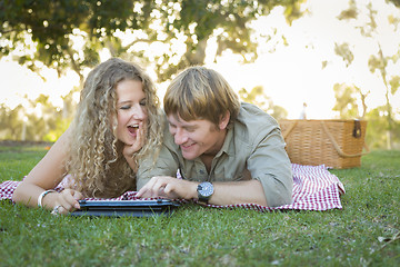 Image showing Attractive Loving Couple Using a Touch Pad Outside