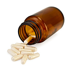 Image showing Capsules in an open jar of brown