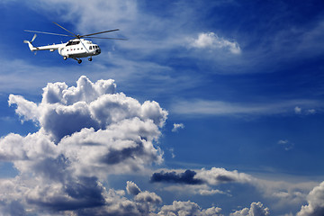 Image showing Helicopter in blue sky with clouds