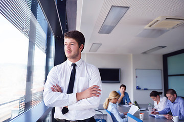 Image showing business man  on a meeting in offce with colleagues in backgroun