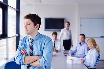 Image showing business man  on a meeting in offce with colleagues in backgroun