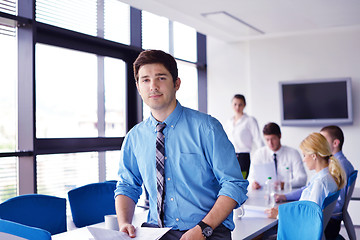 Image showing business man  on a meeting in offce with colleagues in backgroun