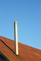 Image showing Chimney on an old tinny roof