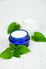 Image showing face cream in jars with urtica leaves 