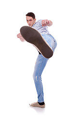 Image showing young casual man kicking 