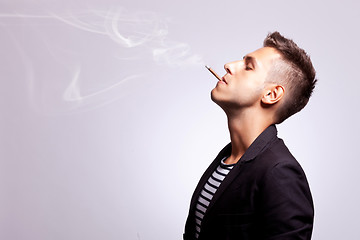 Image showing casual fashion man smoking a cigar