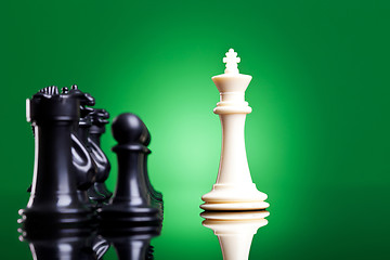 Image showing white king in front of the black chess pieces