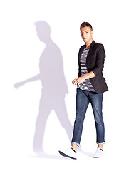 Image showing side view of a young casual fashion man  walking