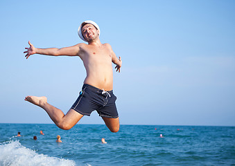 Image showing man jumping of joy on the beach