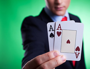 Image showing business man holding a pair of aces