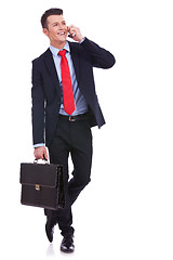 Image showing  business man with briefcase talking on the phone