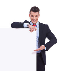 Image showing Young business man presenting a  blank board 