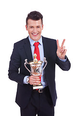 Image showing young business man winning a big trophy 