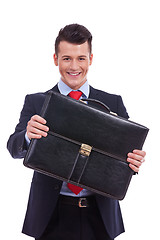 Image showing business man giving his briefcase 