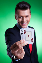 Image showing business man holding a pair of  aces 