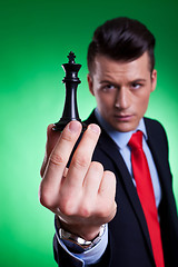 Image showing  business man holding and looking at the black king