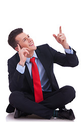 Image showing young seated business man pointing