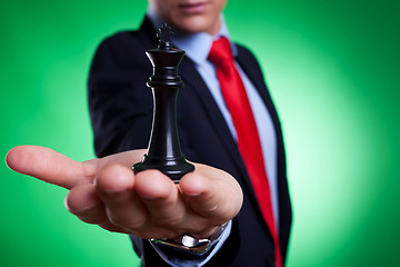 Image showing king of chess in the palm of a young business man