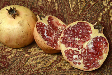 Image showing two pomegranates, one open in the foreground and the background another whole