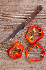 Image showing sliced red bell peppers and old knife