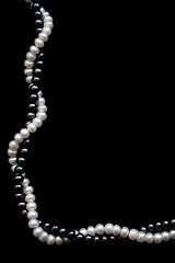 Image showing White and black pearls on a black velvet 