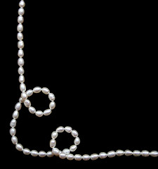 Image showing White pearls on the black silk 