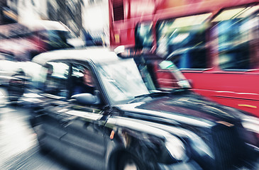 Image showing Motion blur picture of Black Cab and Red Double Decker Bus in th