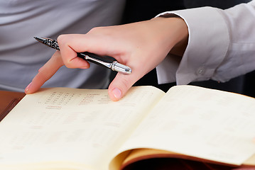 Image showing Woman writing in organizer