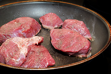 Image showing beef meat on pan with pepper and sea salt